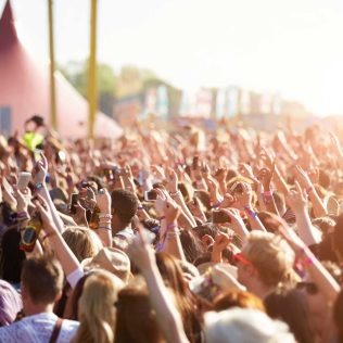 Audience at outdoor music festival | Featured image for the Must See Regional Festivals blog for East Coast Car Rentals.